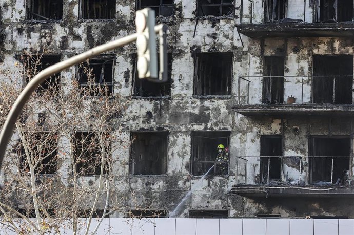 Archivo - Un agente de la Policía Científica busca las causas del incendio en el edificio del barrio de Campanar, a 24 de febrero de 2024, en Valencia