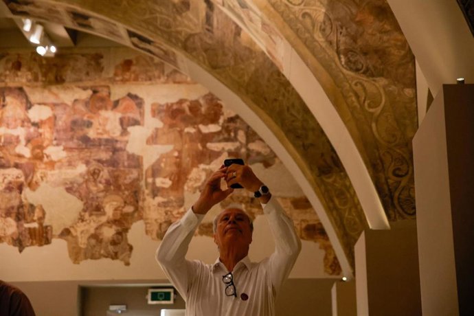 Un hombre fotografía las pinturas murales del Monasterio de Sijena expuestas en el Museu Nacional d’Art de Catalunya (MNAC), a 29 de mayo de 2025