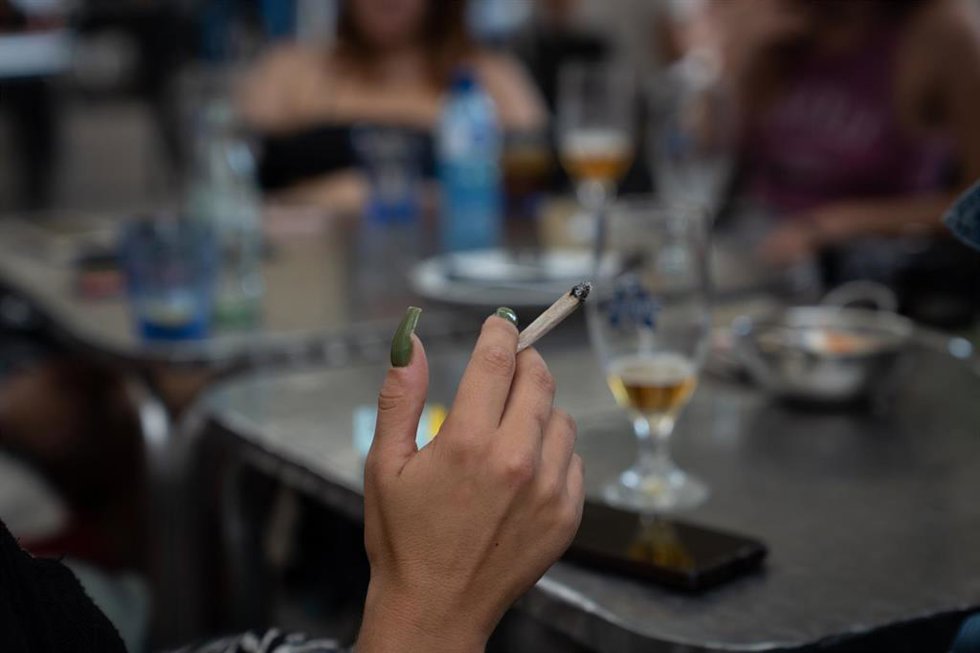 Archivo - Archivo.- Una mujer fuma sentad en la mesa de una terraza