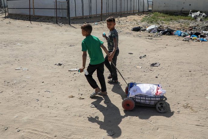 Archivo - GAZA, 2 de abril de 2025 -- Crianças palestinas puxam um carrinho com um saco de farinha no bairro de al-Tuffah, a leste da Cidade de Gaza, em 2 de abril de 2025. Todas as 25 padarias apoiadas pelo Programa Mundial de Alimentos das Nações Unidas