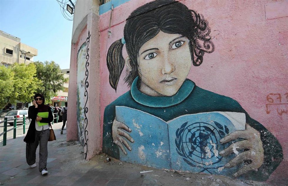 Archivo - Mural de una niña palestina con un libro con el logotipo de la ONU en Gaza