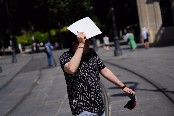 Un hombre se protege del sol con una carpeta. A 28 de mayo de 2025, en Sevilla (Andalucía, España).La Agencia Estatal de Meteorología (Aemet) ha activado para este miércoles el aviso amarillo por calor en diversas zonas de Córdoba, Jaén y Sevilla, donde l