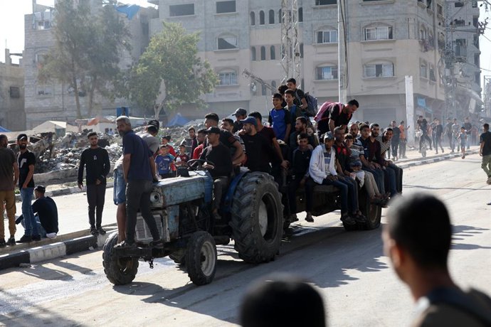 30 de maio de 2025, Nusairat, Faixa de Gaza, Território Palestino: Palestinos deslocados carregando suprimentos de ajuda humanitária retornam de um centro de distribuição de ajuda no centro da Faixa de Gaza em 30 de maio de 2025. A situação humanitária em
