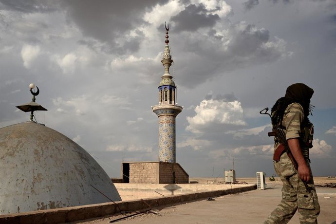Archivo - 1 de outubro de 2014 - Al-Hasakah, Síria - Um combatente do YPG caminha sobre uma mesquita sufi parcialmente destruída em uma posição de linha de frente na guerra contra o ISIS na cidade de Til Meruf. Ao contrário de outros grupos atormentados p