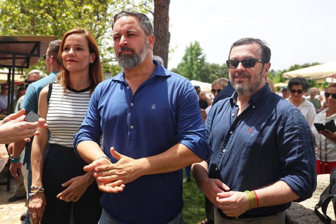 La portavoz de Vox en la Asamblea de Madrid, Isabel Pérez Moñino (i), y el presidente de Vox, Santiago Abascal (c), antes de una comida con afiliados y simpatizantes de Vox, en El Jardín de la Chalota, a 1 de junio de 2025, en Navalagamella, Madrid (Españ
