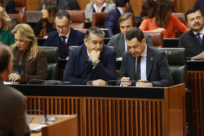 Archivo - El presidente de la Junta de Andalucía, Juanma Moreno (d), junto al consejero de la Presidencia, Interior, Diálogo Social y Simplificación Administrativa, Antonio Sanz (i), en un debate en el Parlamento andaluz en una imagen de archivo