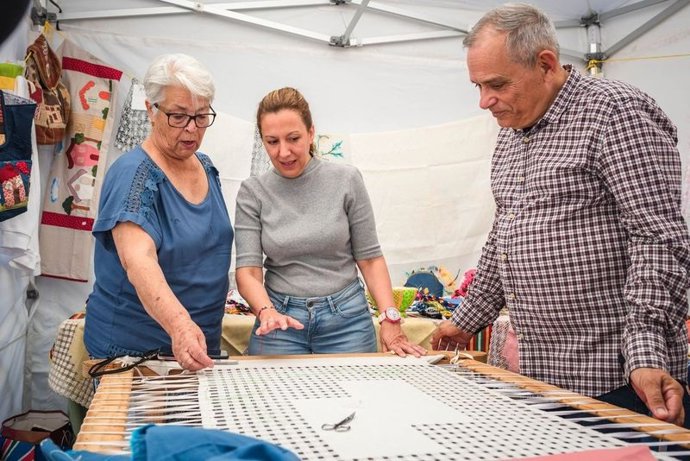 La presidenta del Cabildo de Tenerife, Rosa Dávila (c), y el consejero de Empleo y Educación, Efraín Medina, en una visita a la feria de artesanía de Arafo