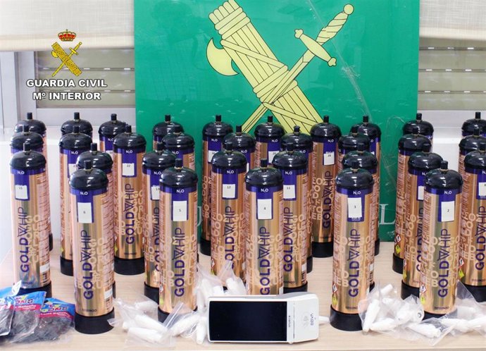 Botellas de óxido nitroso intervenidas por la Guardia Civil en un vehículo abandonado por su conductor, que ha sido detenido, en el arcén de la autovía A-30