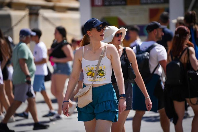 Turistas con ropa veraniega paseando por el casco histórico. A 28 de mayo de 2025, en Sevilla (Andalucía, España).