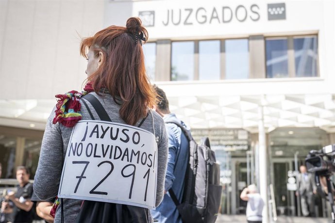 Varias personas en una concentración exigen verdad justicia y reparación para las víctimas del covid-19 en las residencias, con pancartas de las 7291 muertes, frente a los Juzgados de Plaza Castilla, a 26 de mayo de 2025, en Madrid (España).