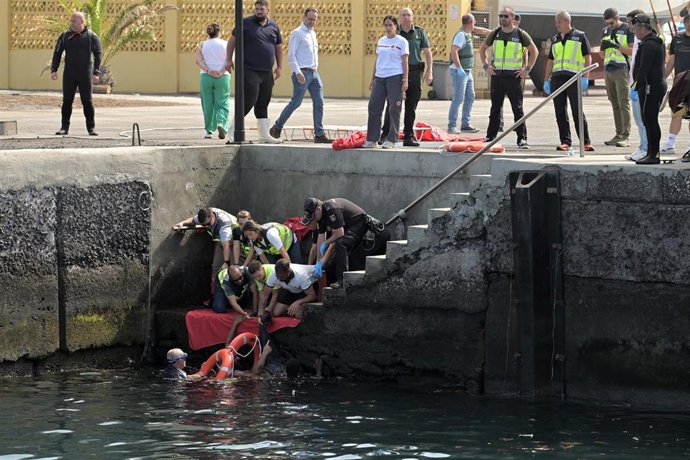 Agentes de Policía Nacional rescatan a uno de los migrantes que viajaba en el cayuco que ha volcado a su llegada al puerto de La Restinga a 28 de mayo de 2025