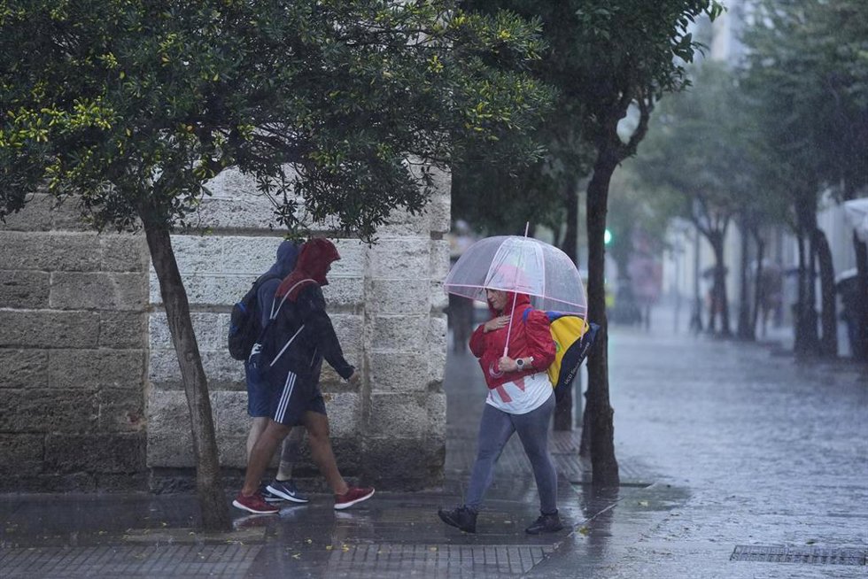 Archivo - Transeuntes bajo sus paraguas durante la intensa lluvia. Imagen de archivo. 