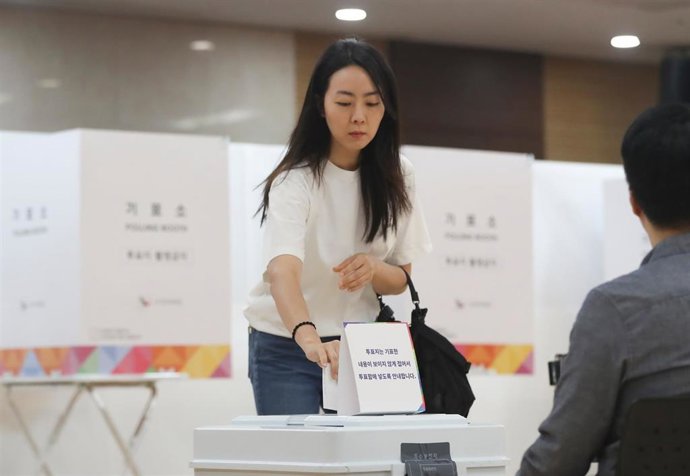 Imagen de archivo de una mujer depositando su voto en un centro de votación de Corea del Sur. 