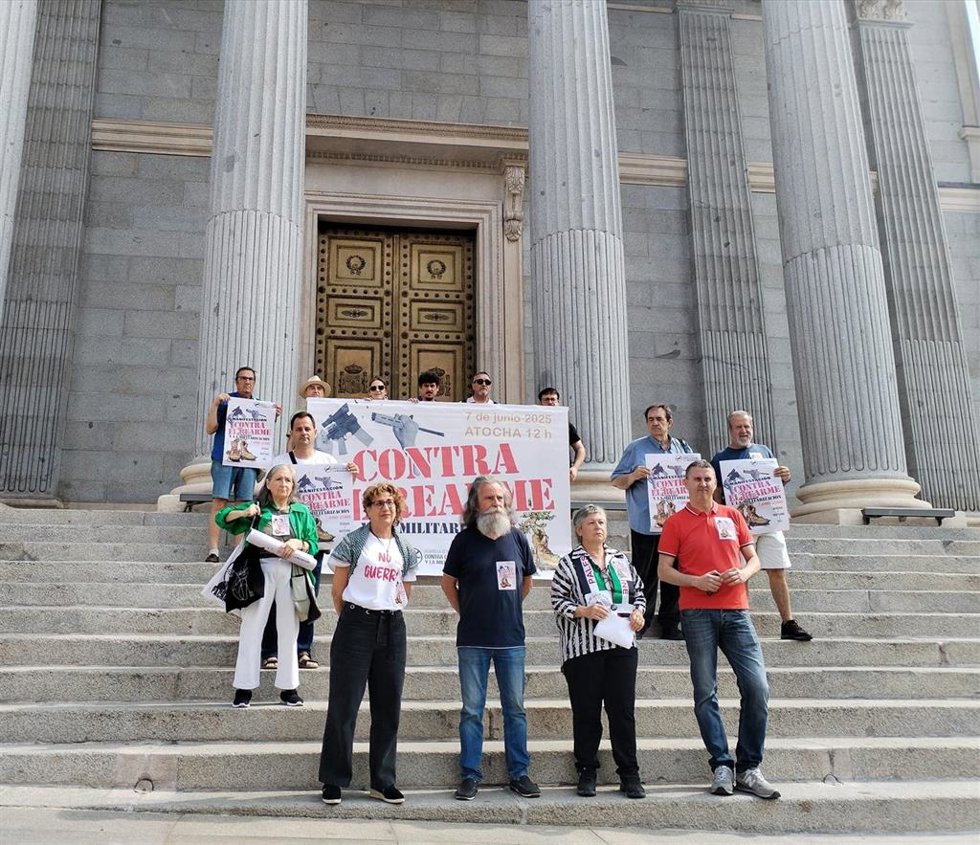 Organizadores de la marcha contra el rearme despliegan una pancarta en la Puerta de los Leones del Congreso de los Diputados