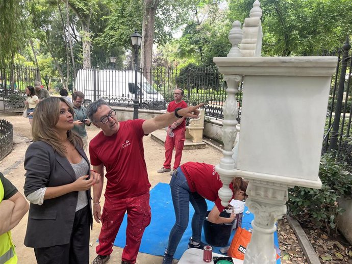 Evelia Rincón comprueba los trabajos de restauración del anaquel de la Glorieta de Bécquer del Parque de María Luisa, vandalizado en 2022.