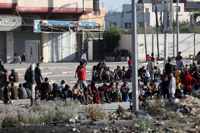 30 de maio de 2025, Nusairat, Faixa de Gaza, Território Palestino: Palestinos deslocados carregando suprimentos de ajuda humanitária retornam de um centro de distribuição de ajuda no centro da Faixa de Gaza em 30 de maio de 2025. A situação humanitária em