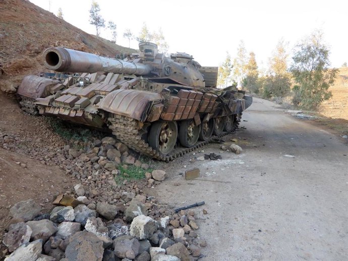 Archivo - Un vehículo blindado sirio dañado y abandonado en la carretera en Tel al Hara, Derá, Siria, tras la ataques de Israel