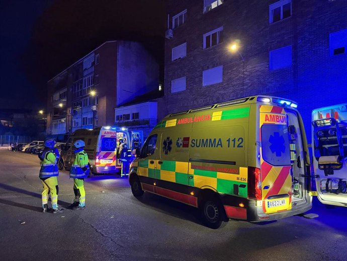 Profesionales sanitarios y de Bomberos ante un edificio de viviendas incendiado en Torrejón de Ardoz
