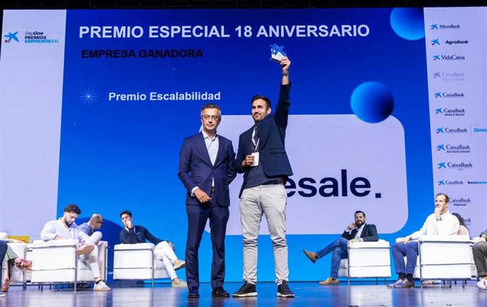 El consejero delegado de TripResale, Eduardo Martínez, recoge el premio de manos de manos del director de CaixaBank Hotels&Tourism, David Rico.