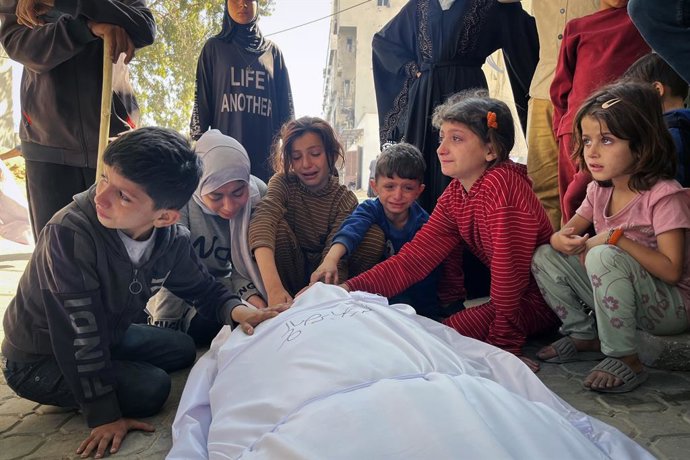 Xiquets palestins junt amb el cos d'un mort a causa d'un bombardeig de l'Exèrcit d'Israel contra la ciutat de Gaza, al nord de la Franja de Gaza (arxiu)