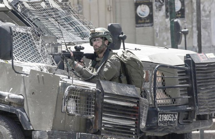 27 de maio de 2025, Nablus, Cisjordânia, Palestina: Soldados israelenses apontam suas armas para palestinos e assumem posições no meio de um mercado. As forças israelenses invadiram o mercado central e várias lojas de ouro e de câmbio de dinheiro, alegand