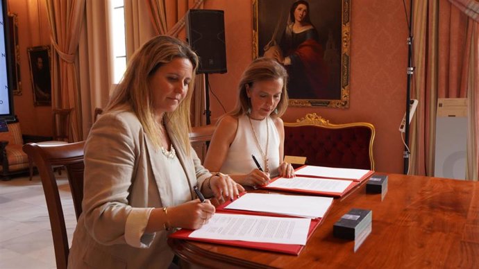 Las delegadas de Turismo de los ayuntamientos de Sevilla y Madrid, Angie Moreno (i) y Almudena Maíllo firman el convenio en el Consistorio hispalense.