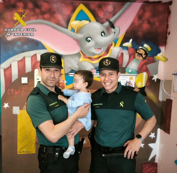 Los dos agentes de la Guardia Civil junto con el bebé al que auxiliaron cuando había sufrido una parada cardiorrespiratoria.