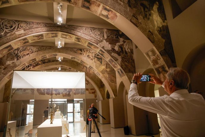 Un hombre fotografía las pinturas murales del Monasterio de Sijena expuestas en el Museu Nacional d’Art de Catalunya (MNAC), a 29 de mayo de 2025, en Barcelona