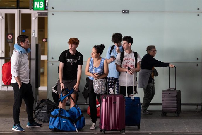 Archivo - Varias personas en el aeropuerto de El Prat de Barcelona