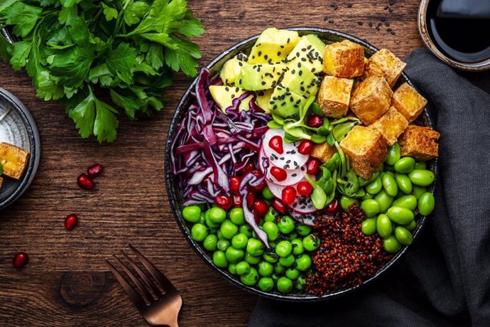 Archivo - Vegan Buddha Bowl for balanced diet with tofu, quinoa, vegetables and legumes. Wooden table background, top view