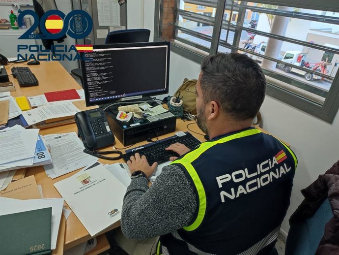 Archivo - Un agente de la Policía Nacional de Sevilla frente a un ordenador, en foto de recurso.