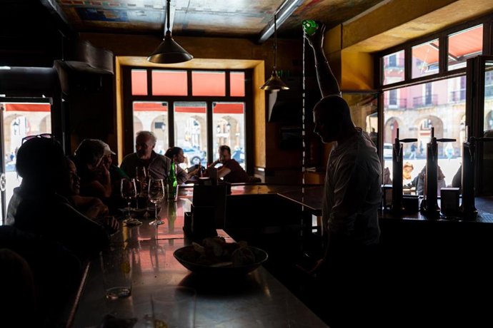 Archivo - Un camarero sirve sidra en un bar.
