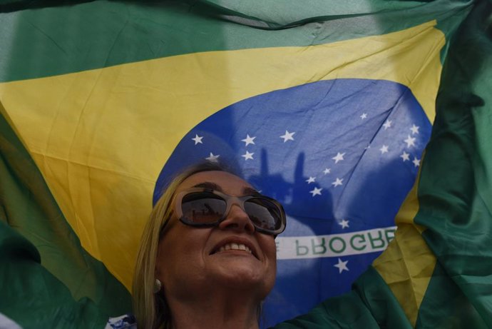 Archivo - 26 May 2019, Brazil, Rio de Janeiro: A woman holds Brazil's national flag as she takes part in a protest at Copacabana to support the decisions of the Brazilian president Jair Bolsonaro. Photo: Fabio Teixeira/ZUMA Wire/dpa