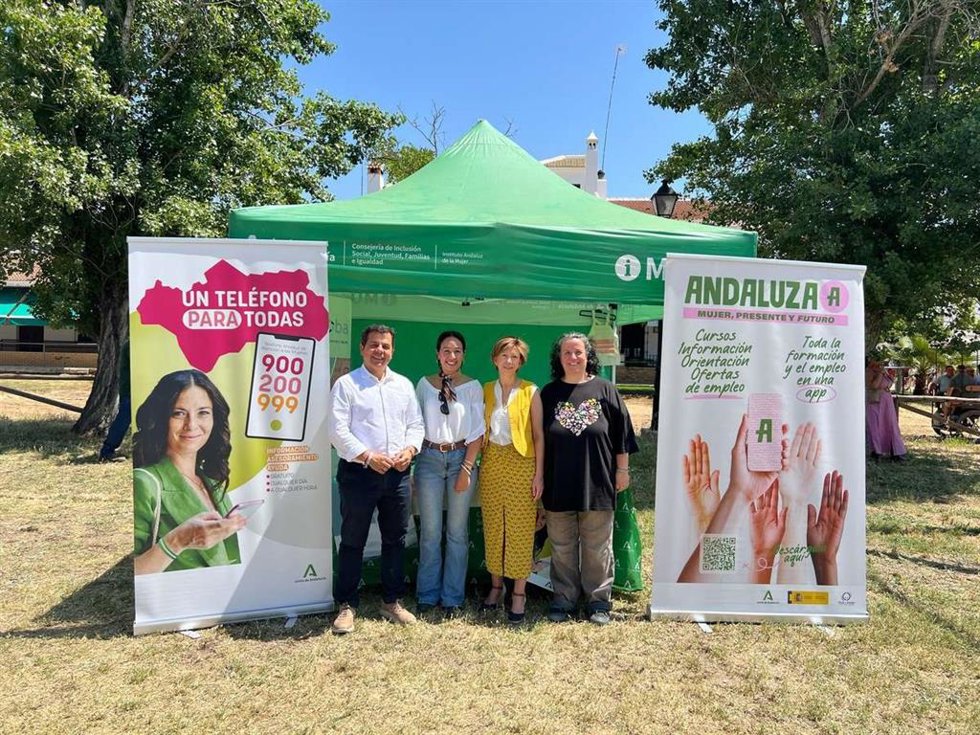 La directora del Instituto Andaluz de la Mujer, Olga Carrión y José Manuel Borrero en el punto InfoMujer de El Rocío junto al personal que lo atiende.