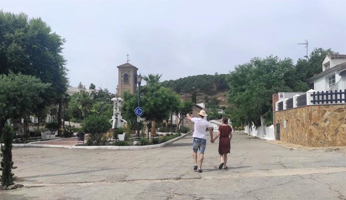 Dos turistas observan la plaza de la iglesia en la población de El Centenillo.
