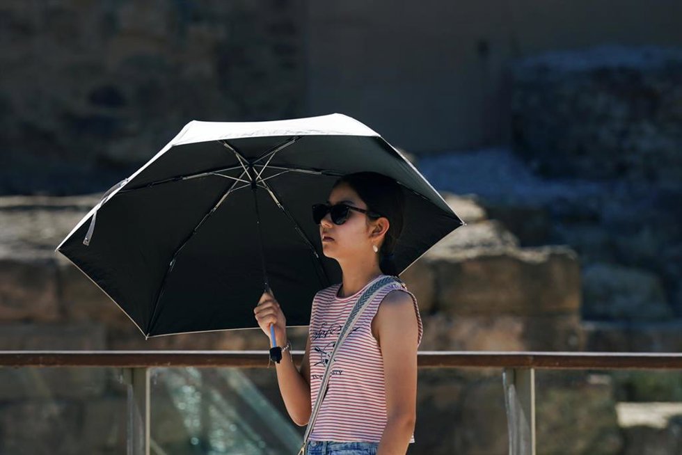 Archivo - Una persona se protege con un paraguas del calor en Málaga, en una imagen de archivo. 