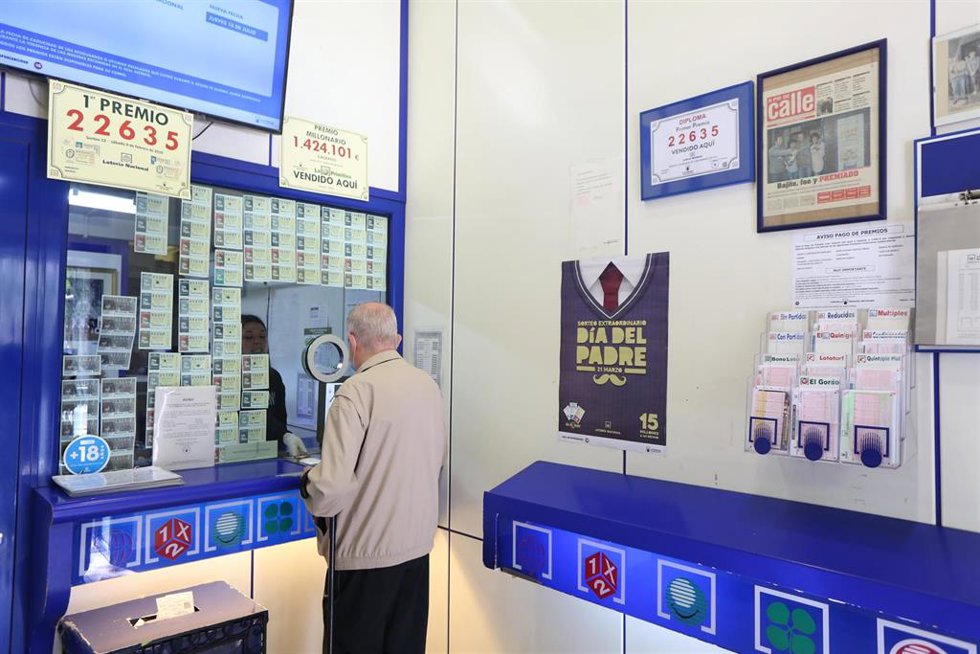 Archivo - Un hombre compra lotería en una Administración de Lotería.
