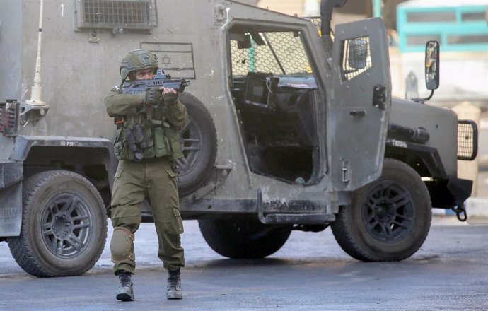 25 May 2025, Palestinian Territories, Nablus: An Israeli soldier fires a shot in the air during a military operation in the center of Nablus. Israeli army forces raided a house in the old city center of Nablus, in the West Bank. Palestinian residents repo