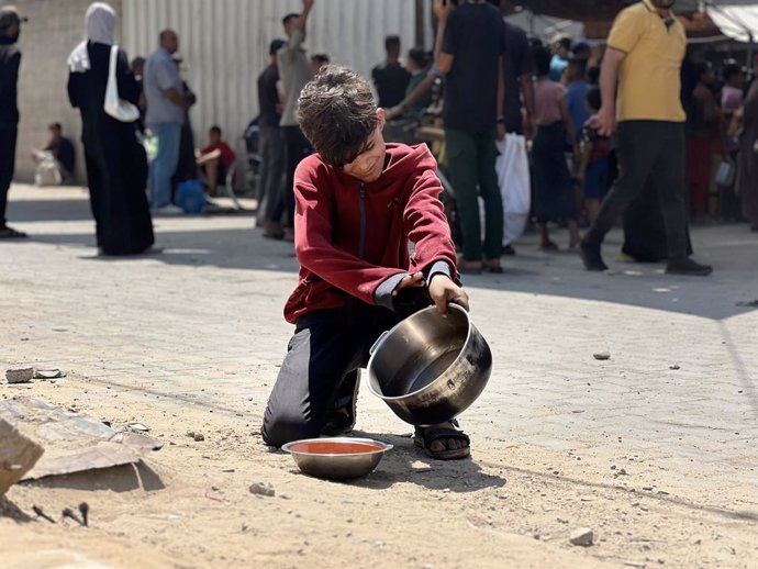June 5, 2025, Nusairat, Gaza Strip, Palestinian Territory: Internally displaced Palestinians gather in a charity kitchen to receive limited rations amid a shortage of food, in Nuseirat Palestinian refugee camp, central of Gaza Strip, June 5, 2025. The Uni