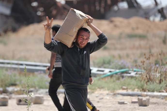 29 de maio de 2025, Bureij, Faixa de Gaza, Território Palestino: Palestinos caminham com suprimentos de ajuda que receberam da Fundação Humanitária de Gaza, apoiada pelos EUA, em Al-Bureij, no centro da Faixa de Gaza, em 29 de maio de 2025