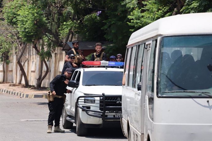 Coche policial escolta a un furgón con detenidos en su interior en Latakia, Siria