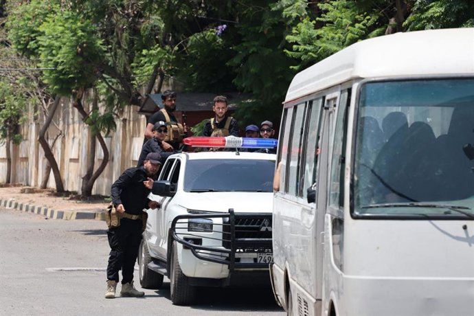 Carro de polícia escoltando uma van com detentos dentro em Latakia, Síria