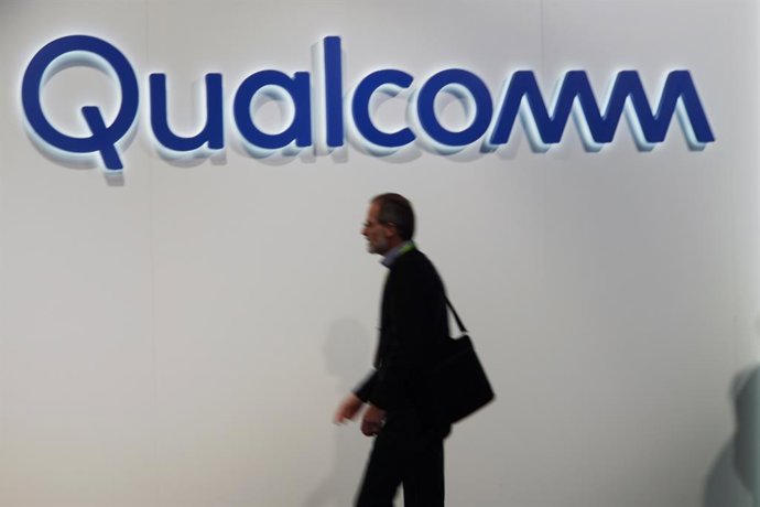 Archivo - FILED - 09 de janeiro de 2019, EUA, Las Vegas: Visitantes da feira de eletrônicos CES passam por um logotipo da Qualcomm. Foto: Christoph Dernbach/dpa