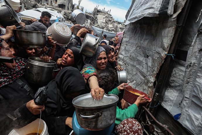 Archivo - Arquivo - 27 de abril de 2025, Territórios Palestinos, Beit Lahia: Palestinos se empurram na fila para receber uma porção de comida de uma cozinha beneficente, em Beit Lahia, no norte da Faixa de Gaza. De acordo com a agência de refugiados pales