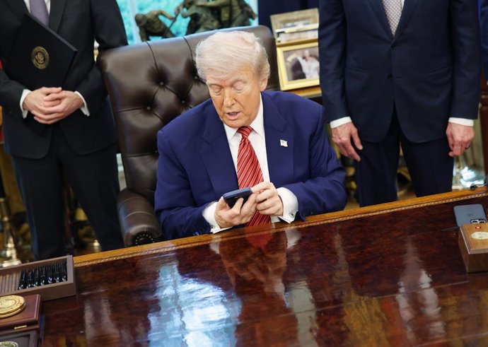 23 de maio de 2025, Washington, Distrito de Colúmbia, EUA: O presidente dos Estados Unidos, Donald J. Trump, verifica seu telefone enquanto assina ordens executivas relacionadas à energia nuclear no Salão Oval da Casa Branca em Washington, DC, EUA, em 23 