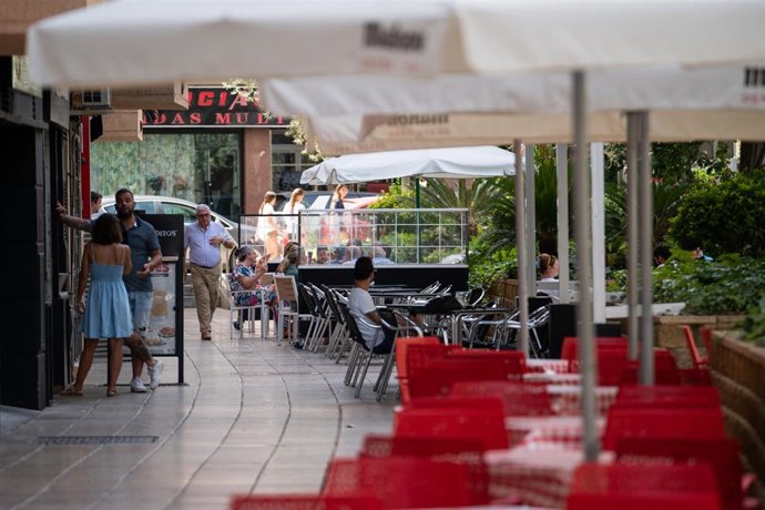 Archivo - Varias personas sentadas en una terraza