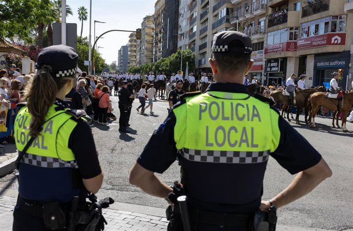 Dos agentes de la Policía Local durante la salida de la Hermandad de Huelva.