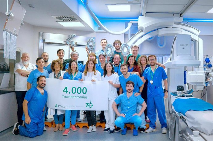 Profesionales del Hospital Universitario Virgen del Rocío muestran un cartel con las 4.000 trombectomías realizadas en su lucha contra el ictus.