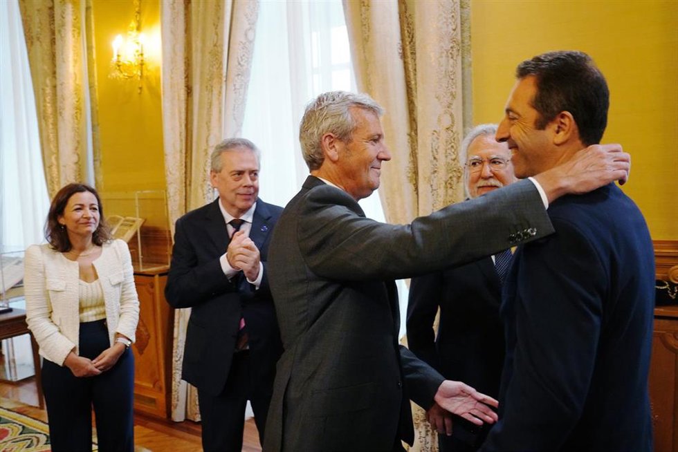 El presidente de la Xunta, Alfonso Rueda, abraza al hasta ahora conselleiro do Mar, Alfonso Villares, en el acto de posesión de la nueva conselleira