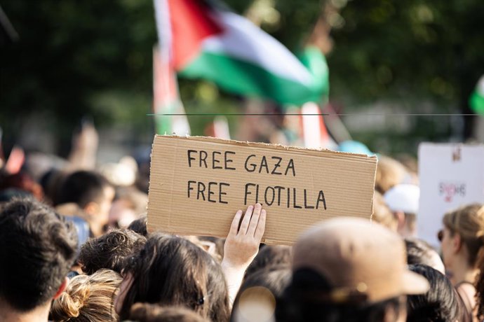 9 de junho de 2025, Paris, França: Um manifestante segura um cartaz que diz "Free Gaza Free Flotilla" durante uma manifestação. Milhares de pessoas se reuniram na Place de République, em Paris, para apoiar os palestinos e pedir a "libertação" da tripulaçã